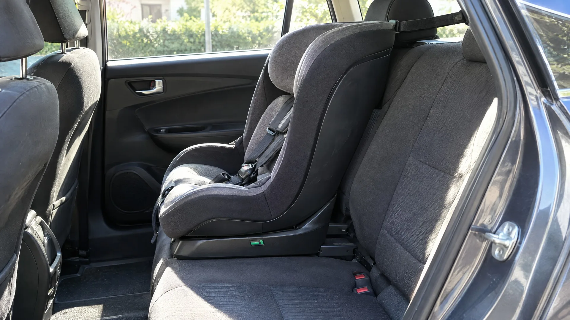 Scaun auto pentru copii prins pe Isofix, cu chinga top tether întinsă peste spătarul banchetei spre ancorajul din spate