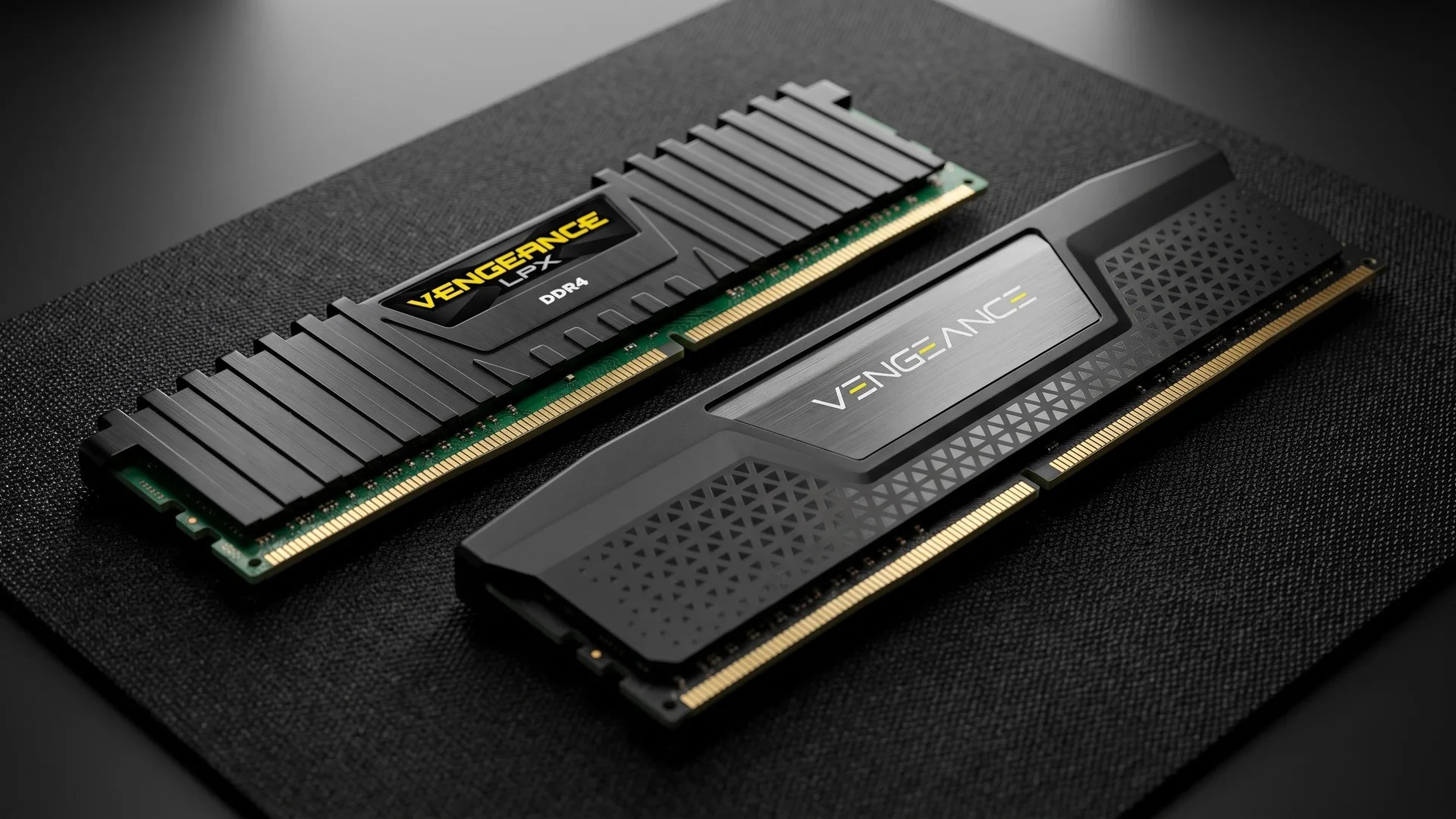 Două module de memorie RAM, DDR4 și DDR5, așezate lângă sloturile DIMM ale unei plăci de bază